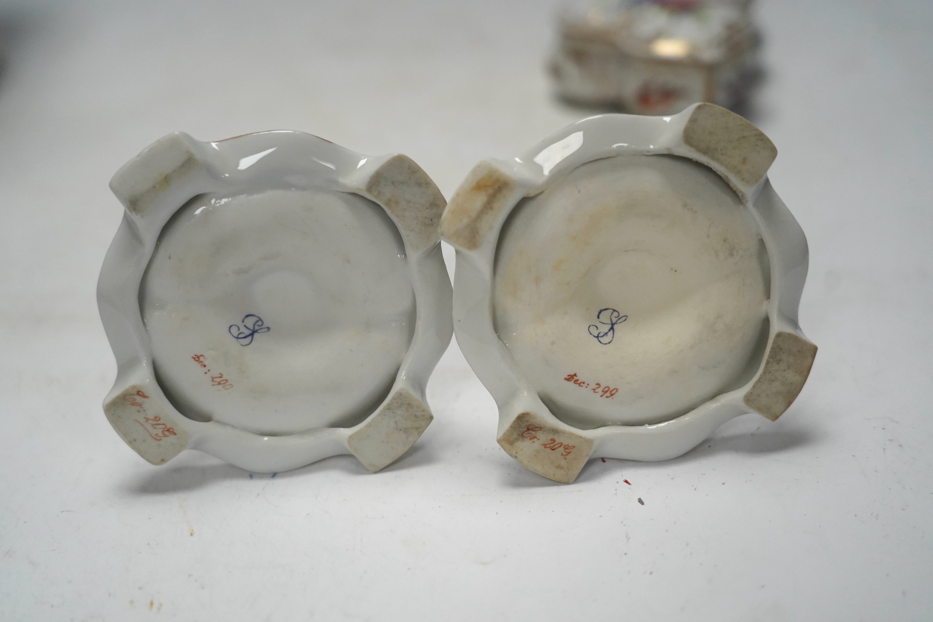 A porcelain shell-shaped centrepiece, a Dresden pill box, a pair of taper holders and a porcelain figure, tallest 21cm